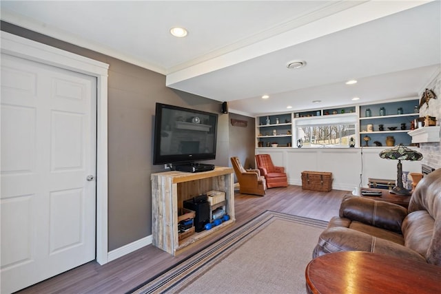 living room featuring crown molding, baseboards, wood finished floors, and recessed lighting