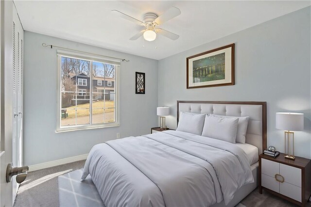 carpeted bedroom with ceiling fan and baseboards