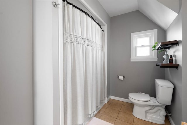 bathroom featuring curtained shower, lofted ceiling, toilet, tile patterned flooring, and baseboards