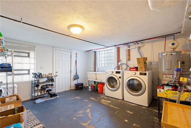 clothes washing area featuring a sink, water heater, a textured ceiling, and washing machine and clothes dryer