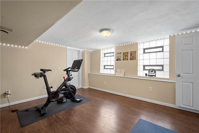 workout room with baseboards and wood finished floors