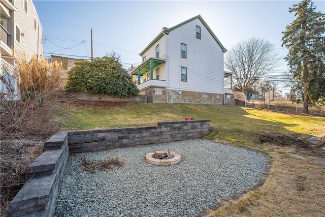 view of side of property with a fire pit and a yard