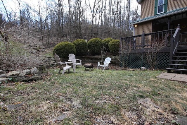 view of yard with a deck, stairway, and a fire pit