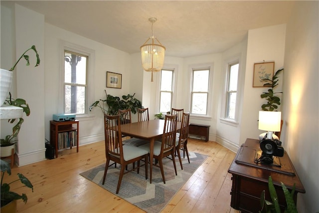 dining area featuring an inviting chandelier, a wealth of natural light, and light wood-style floors