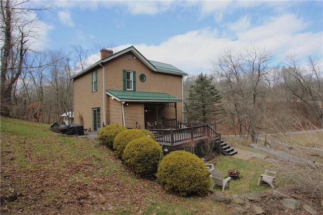 view of front of house featuring a chimney, a fire pit, and a wooden deck