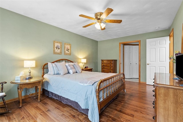 bedroom featuring a closet, wood finished floors, a ceiling fan, and baseboards