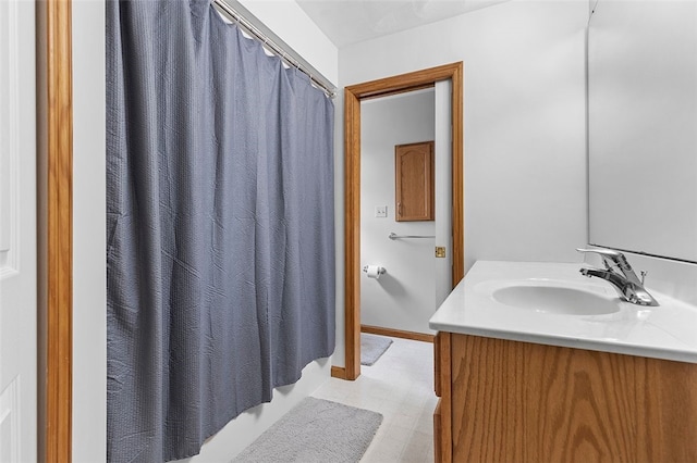 bathroom with baseboards, vanity, and a shower with curtain