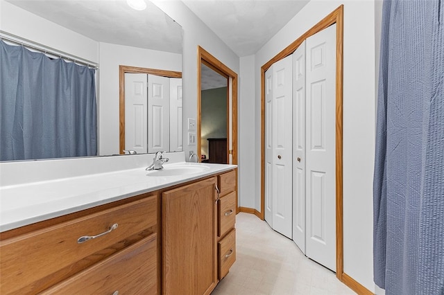 bathroom featuring tile patterned floors, baseboards, a closet, and vanity