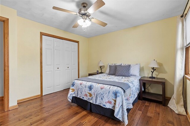 bedroom featuring ceiling fan, a closet, baseboards, and wood finished floors