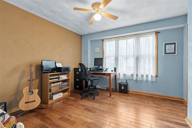 office area with a ceiling fan, baseboards, and hardwood / wood-style flooring