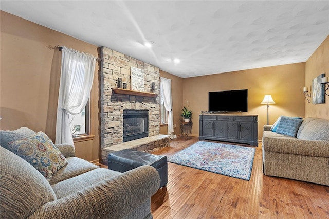 living area with hardwood / wood-style floors, a fireplace, and baseboards