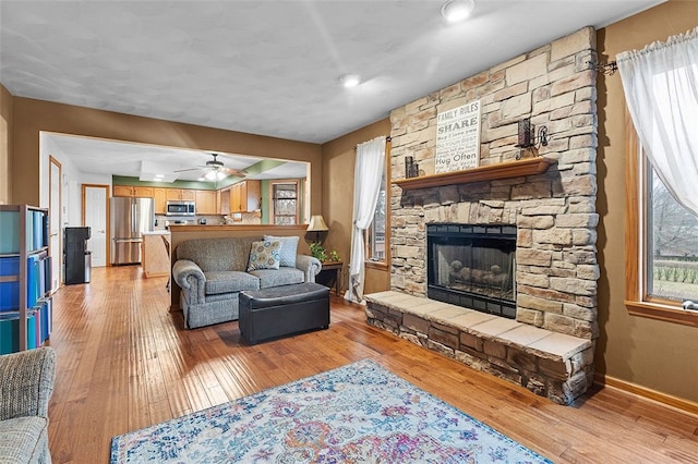 living area featuring plenty of natural light, light wood-type flooring, and a fireplace