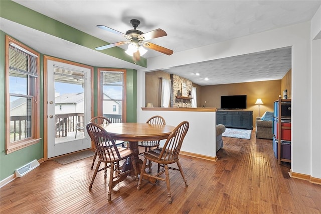 dining area featuring visible vents, baseboards, and hardwood / wood-style flooring