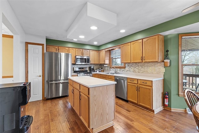 kitchen featuring appliances with stainless steel finishes, light wood-type flooring, and tasteful backsplash