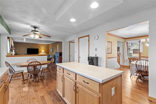 kitchen featuring recessed lighting, a kitchen island, light countertops, light wood-type flooring, and light brown cabinetry