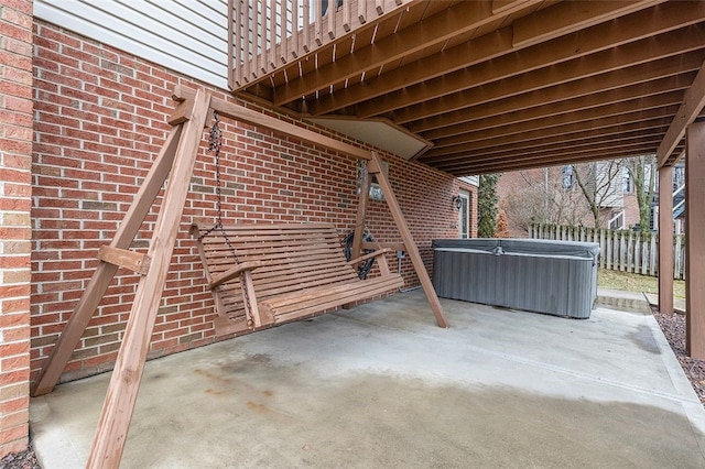 view of patio featuring fence and a hot tub