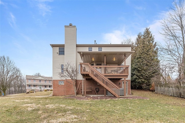 back of house with a chimney, a yard, a deck, and stairs