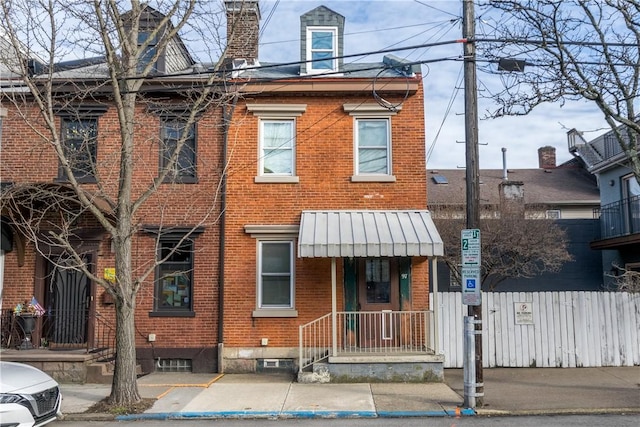 view of front facade with fence and brick siding