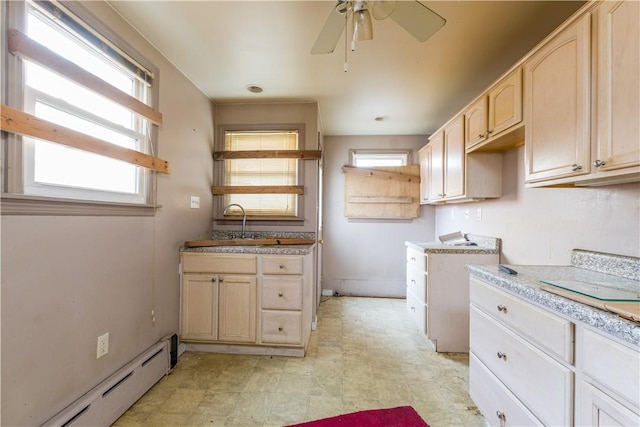 kitchen with a baseboard radiator, ceiling fan, light countertops, light brown cabinetry, and light floors