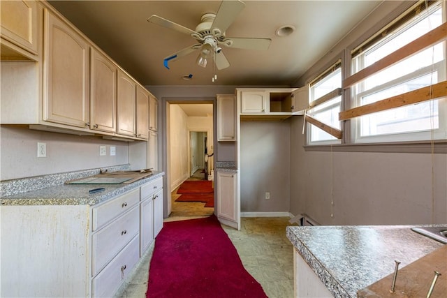 kitchen with light floors, baseboards, and a ceiling fan