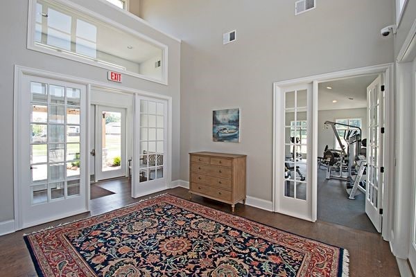 entryway featuring french doors, baseboards, a high ceiling, visible vents, and wood finished floors