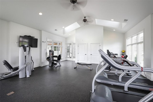 exercise room featuring vaulted ceiling with skylight, baseboards, visible vents, ceiling fan, and recessed lighting