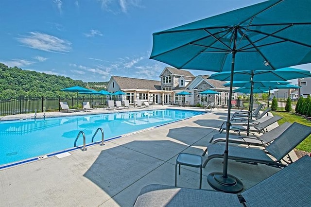community pool with fence and a patio area
