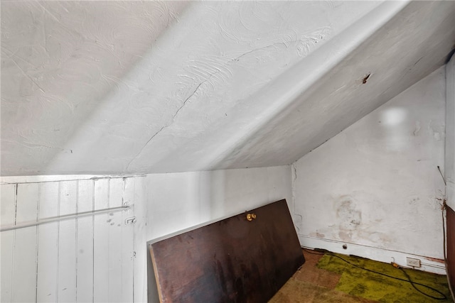 additional living space featuring lofted ceiling and a textured ceiling