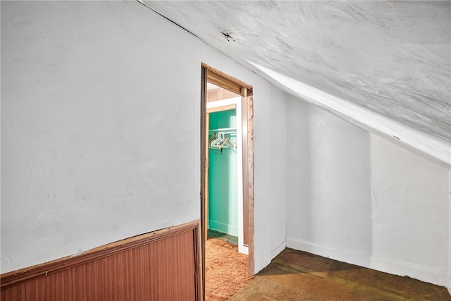 additional living space with a wainscoted wall and vaulted ceiling