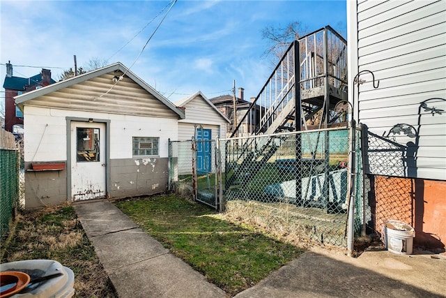 exterior space featuring an outbuilding, fence, and a gate