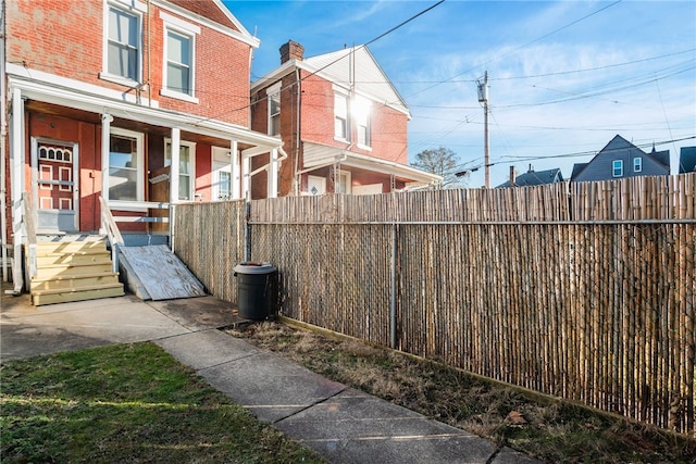 view of yard featuring covered porch and fence