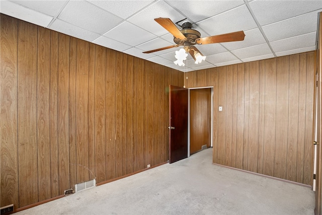 spare room featuring carpet flooring and wood walls