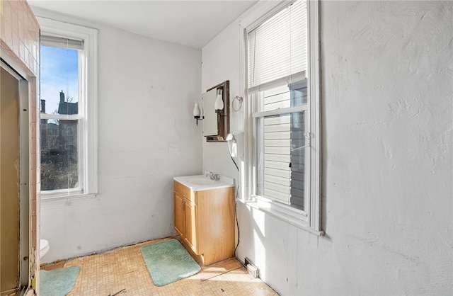 bathroom with a healthy amount of sunlight, vanity, and toilet