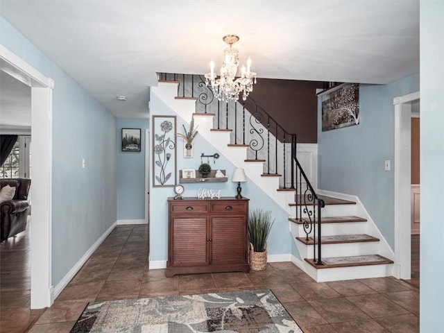 entrance foyer with baseboards, stairway, and a notable chandelier