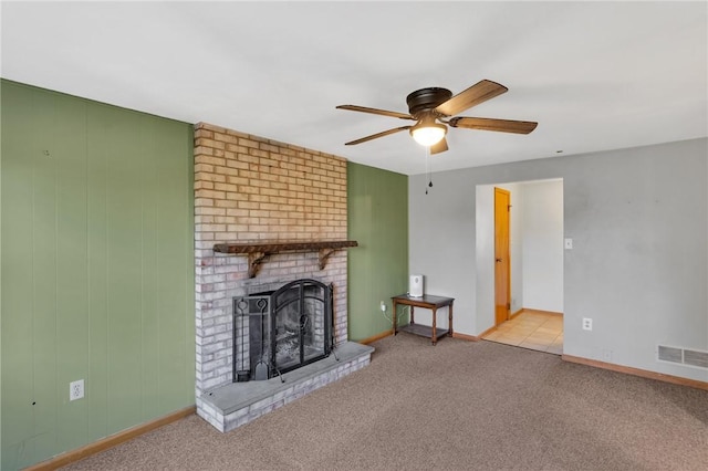 unfurnished living room featuring a ceiling fan, baseboards, visible vents, a brick fireplace, and carpet