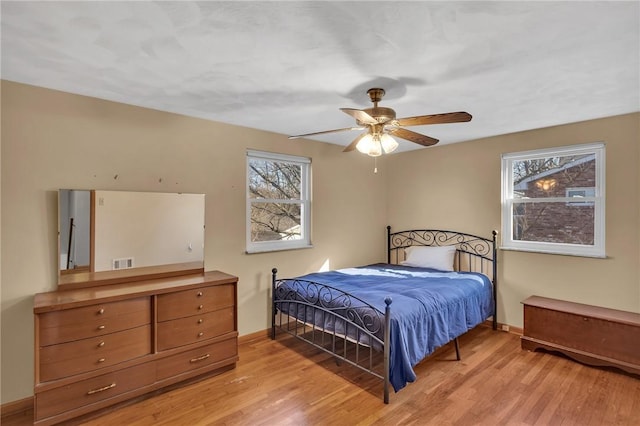 bedroom with light wood-style flooring, multiple windows, and visible vents