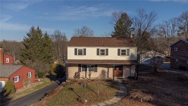 traditional-style house featuring covered porch and brick siding