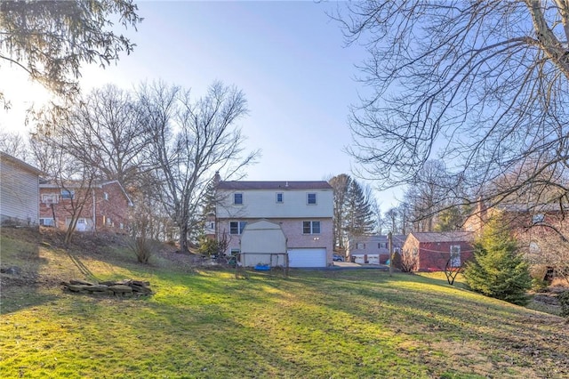 rear view of property featuring a garage and a yard