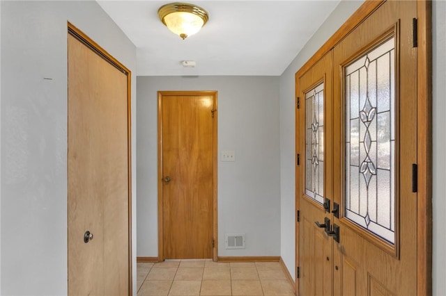 foyer entrance featuring light tile patterned flooring, visible vents, and baseboards