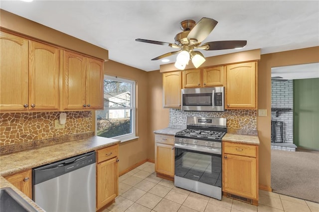 kitchen with light tile patterned floors, ceiling fan, stainless steel appliances, and backsplash