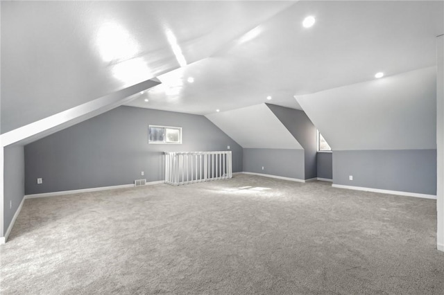 additional living space with lofted ceiling, carpet, visible vents, and baseboards