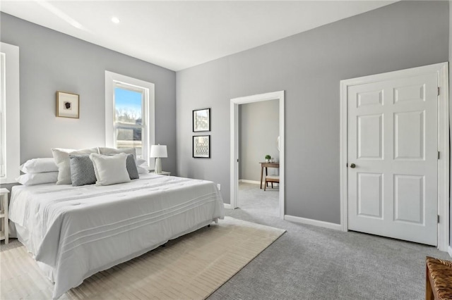 bedroom featuring light colored carpet and baseboards