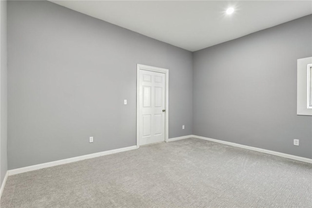 unfurnished room featuring carpet and baseboards