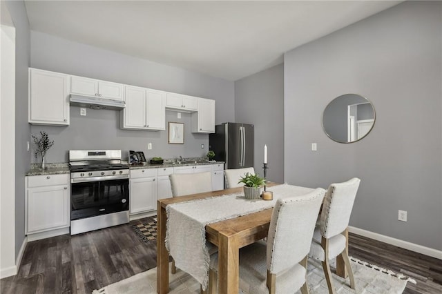 kitchen featuring stainless steel appliances, white cabinets, under cabinet range hood, and dark wood-type flooring