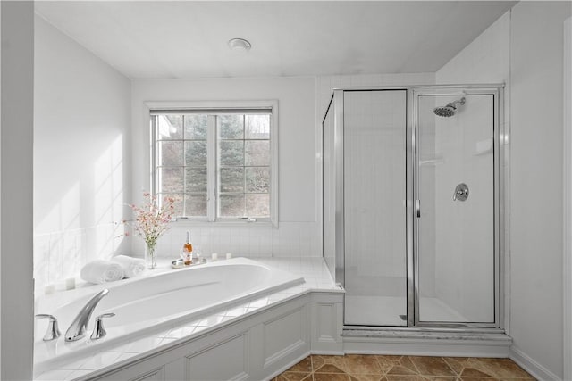 bathroom featuring tile patterned flooring, a shower stall, and a bath