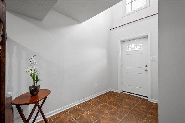 foyer featuring plenty of natural light and baseboards