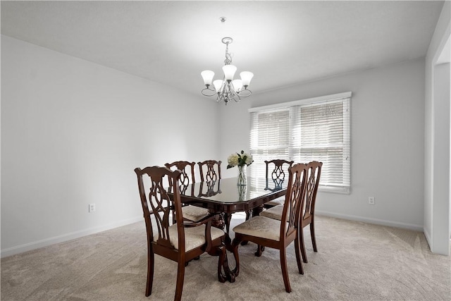 dining area with light carpet, baseboards, and an inviting chandelier