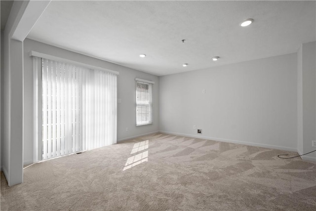 empty room with carpet floors, recessed lighting, and baseboards