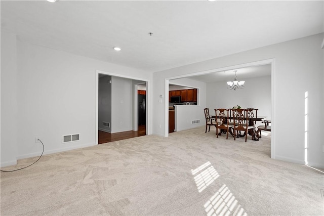 interior space with carpet floors, visible vents, and a notable chandelier