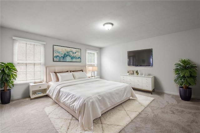 bedroom with light carpet and baseboards